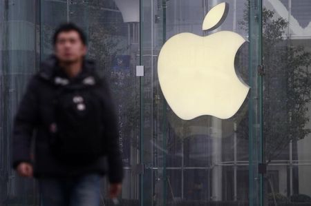 © Reuters. A man walks in front of a company logo outside an Apple store in downtown Shanghai