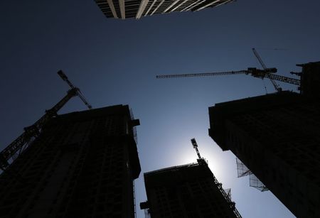 © Reuters. Construction sites of new high-risen buildings are silhouetted at a financial district in Tianjin