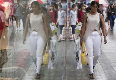 © Reuters. A woman carries shopping bags as she walks along Oxford Street in central London