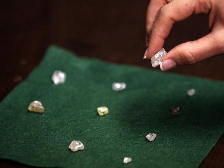 © Reuters. A visitor holds a 17 carat diamond at a Petra Diamonds mine in Cullinan