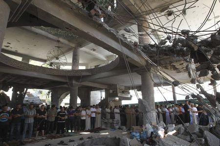 © Reuters. Palestinians perform Friday prayers in the remains of a mosque, which witnesses said was hit by an Israeli air strike during a seven-week Israeli offensive, in Gaza City