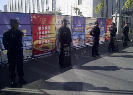 © Reuters. Policemen in riot gear guard a checkpoint on a road near a courthouse where ethnic Uighur academic Ilham Tohti's trial is taking place in Urumqi, Xinjiang Uighur Autonomous Region