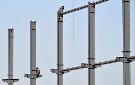 © Reuters. File photo of labourers installing steel frames to a new food factory in Taiyuan