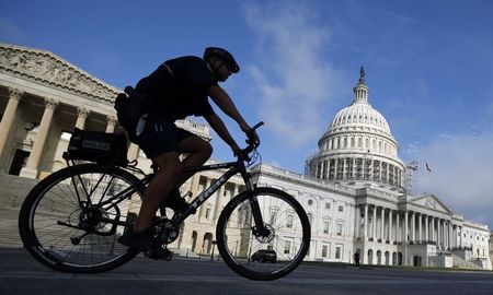 © Reuters. A policeman on a bicycle passes the U.S. Capitol in Washington