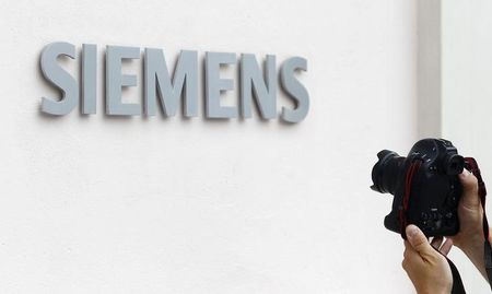 © Reuters. Photographer takes picture of Siemens logo at Germany's Siemens AG headquarter during board member meeting in Munich