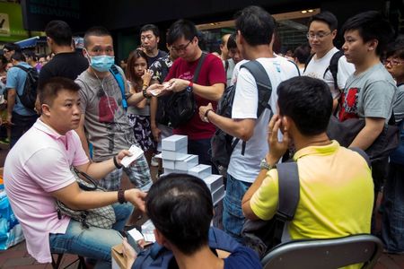 © Reuters. Traders buy the newly-released Apple iPhone 6 and iPhone 6 Plus smart phones from people who bought the phones earlier from the Apple store, at Hong Kong's Mongkok shopping district