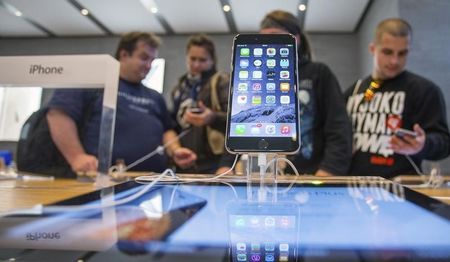 © Reuters. People try out the newly released iPhone 6 at the Apple store in Berlin