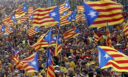 © Reuters. People hold "estelada" flags, Catalan separatist flags, as they form a "V" for "vote" during a gathering to mark the Calatalonia day "Diada" in central Barcelona