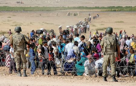 © Reuters. Soldados turcos de guarda diante de curdos sírios na fronteira da Turquia em Suruc, na província de Sanliurfa