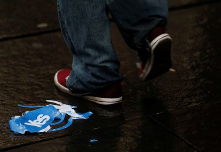 © Reuters. A man walks past a discarded "Yes" campaign paper hat on the Royal Mile after the referendum on Scottish independence in Edinburgh