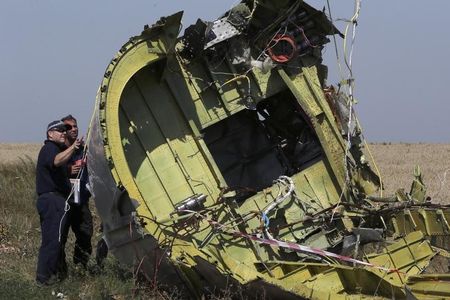 © Reuters. Members of a group of international experts inspect the territory at the site where the downed Malaysia Airlines flight MH17 crashed, near the village of Hrabove