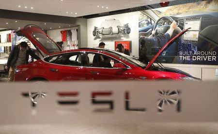 © Reuters. A man looks around Tesla Motors' Model S P85 at its showroom in Beijing