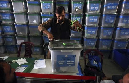 © Reuters. An Afghan election worker opens the lock to a ballot box to start counting ballot papers for an audit of the presidential run-off in Kabul