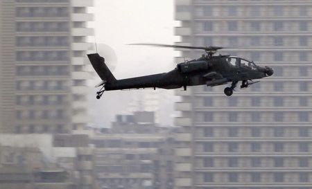 © Reuters. An Apache helicopter flies over Tahrir Square during a protest to support the army, in Cairo