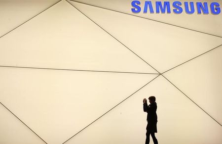 © Reuters. A woman takes a picture outside the Samsung stand at the Mobile World Congress in Barcelona 