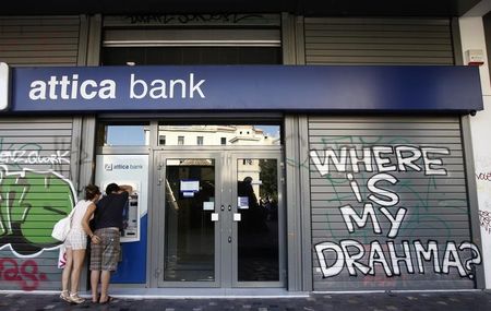 © Reuters. A couple makes a transaction at an ATM outside an Attica bank branch in Athens