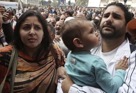 © Reuters. Alaa Abdel Fattah arrives with his wife and child to the public prosecutor's office in Cairo