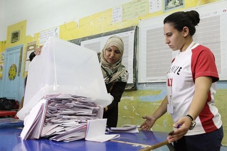 © Reuters. People count ballots during parliamentary elections in Tunis