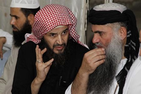 © Reuters. Radical Muslim cleric Abu Qatada listens to Islamist scholar Sheik Abu Mohammad al Maqdisi during a celebration after his release from a prison near Amman