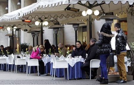 © Reuters. A couple looks at a restaurant menu in downtown Milan