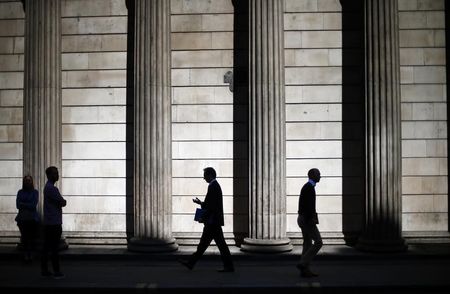 © Reuters. People are silhouetted as they walk past the columns of the Bank of England in the City of London