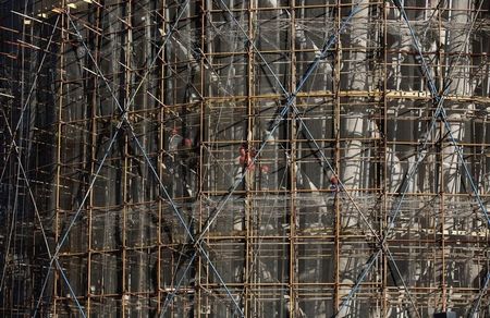 © Reuters. Workers labour at a construction site in Beijing