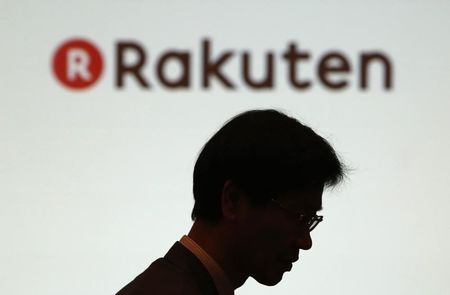 © Reuters. A man walks under a logo of Rakuten Inc during a news conference in Tokyo