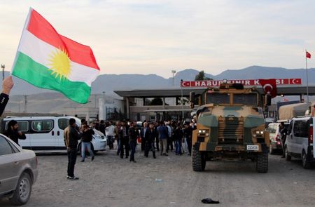 © Reuters. A man waves a Kurdistan flag as a Turkish military truck escorts a convoy of peshmerga vehicles at Habur border gate, which separates Turkey from Iraq, near the town of Silopi in southeastern Turkey