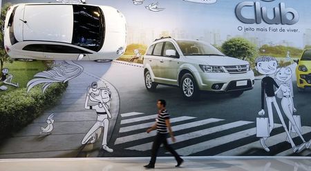 © Reuters. A man walks past a Fiat billboard during the International Sao Paulo Motor Show media day in Sao Paulo