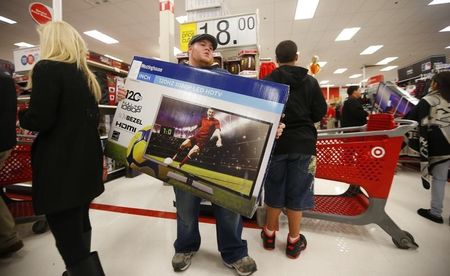 © Reuters. Thanksgiving Day holiday shopper carries a discounted television to the checkout at the Target retail store in Chicago