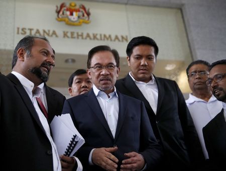 © Reuters. Malaysia's opposition leader Anwar Ibrahim is seen with his defence team as he leaves the court during his final appeal against a conviction for sodomy at the Palace of Justice in Putrajaya