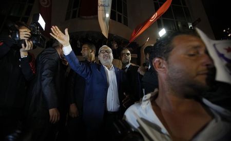 © Reuters. Rached Ghannouchi, leader of the Islamist party Ennahda, waves after giving a speech outside Ennahda's headquarters in Tunis