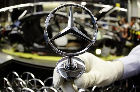 © Reuters. An employee of German car manufacturer Mercedes Benz holds the characteristic Mercedes star before it gets installed on the bonnet of a Mercedes S-class limousine during a photo opportunity at the Mercedes plant in Sindelfingen near Stuttgart