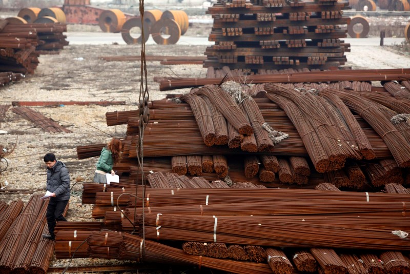 &copy; Reuters File photo of employees of a steel company working at a steel market in Shanghai