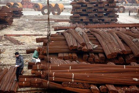 © Reuters. File photo of employees of a steel company working at a steel market in Shanghai