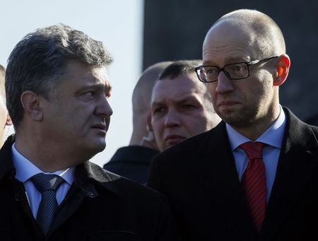 © Reuters. Ukraine's President Poroshenko talks to Prime Minister Yatseniuk after a wreath laying ceremony at the Unknown Soldier's Tomb in Kiev