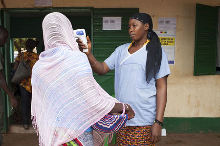 © Reuters. Profissional de saúde verifica temperatura em mulher que deixou Guiné, na fronteira com Mali 