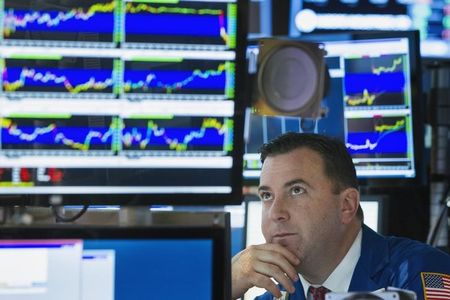 © Reuters. A trader looks up at screen as he works on floor of New York Stock Exchange shortly before closing of the market in New York