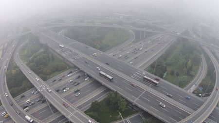 © Reuters. Vehicles drive on the Sihui overpass amid heavy haze and smog in Beijing