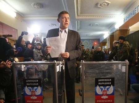 © Reuters. Zakharchenko, separatist leader of the self-proclaimed Donetsk People's Republic, holds his ballot papers before voting during its leadership and local parliamentary elections at a polling station in Donetsk