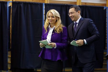 © Reuters. Romania's Prime Minister Ponta and his wife Sarbu prepare to cast their votes at a polling station in Bucharest