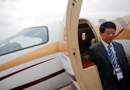 © Reuters. File photo of a visitor standing next to a Piaggio Avanti II business aircraft during the Shanghai International Business Aviation Show at Hongqiao International Airport in Shanghai