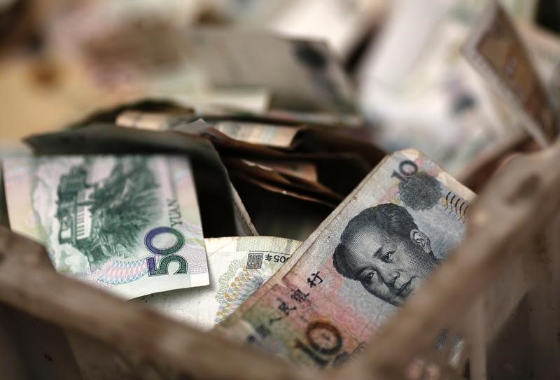 &copy; Reuters Chinese banknotes are seen at a vendor's cash box at a market in Beijing