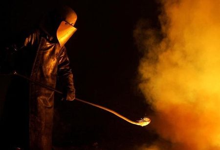 © Reuters. Worker at Arcelor steel plant works at furnace in Uckange