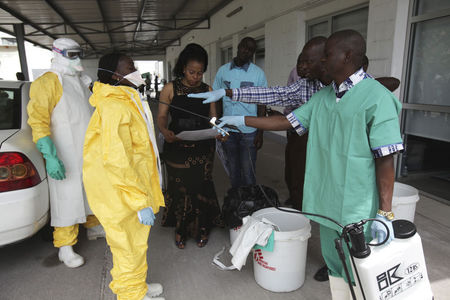 © Reuters. A health worker sprays a colleague with disinfectant during a training session for Congolese health workers to deal with Ebola virus in Kinshasa