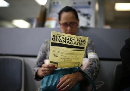 © Reuters. Murillo reads a leaflet at a health insurance enrollment event in Cudahy, California