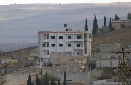 © Reuters. An Islamic State flag is seen in east Kobani