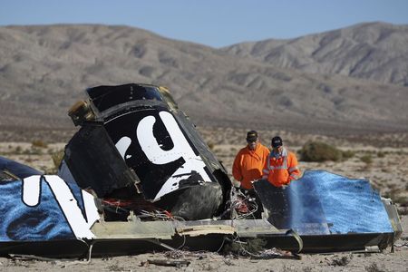 © Reuters. Sheriffs' deputies look at wreckage from the crash of Virgin Galactic's SpaceShipTwo near Cantil, California