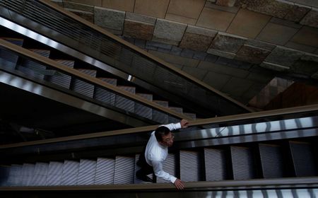 © Reuters. A man rides on an escalator at a business district in Tokyo