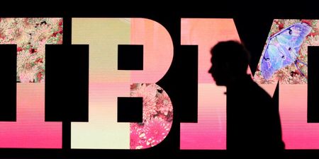 © Reuters. A man passes by an illuminated IBM logo at the CeBIT computer fair in Hanover